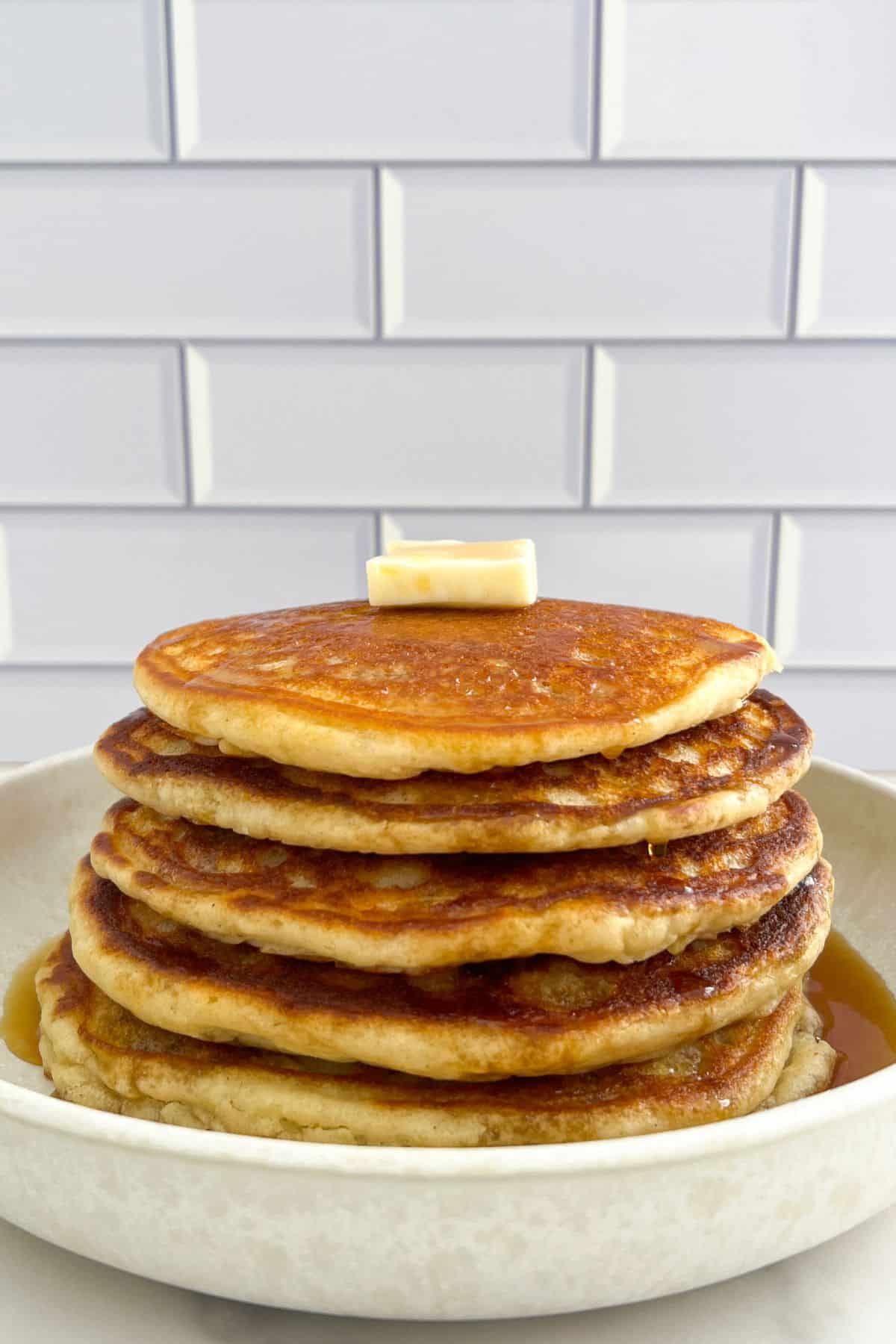 stack of buttermilk protein pancakes topped with butter and maple syrup
