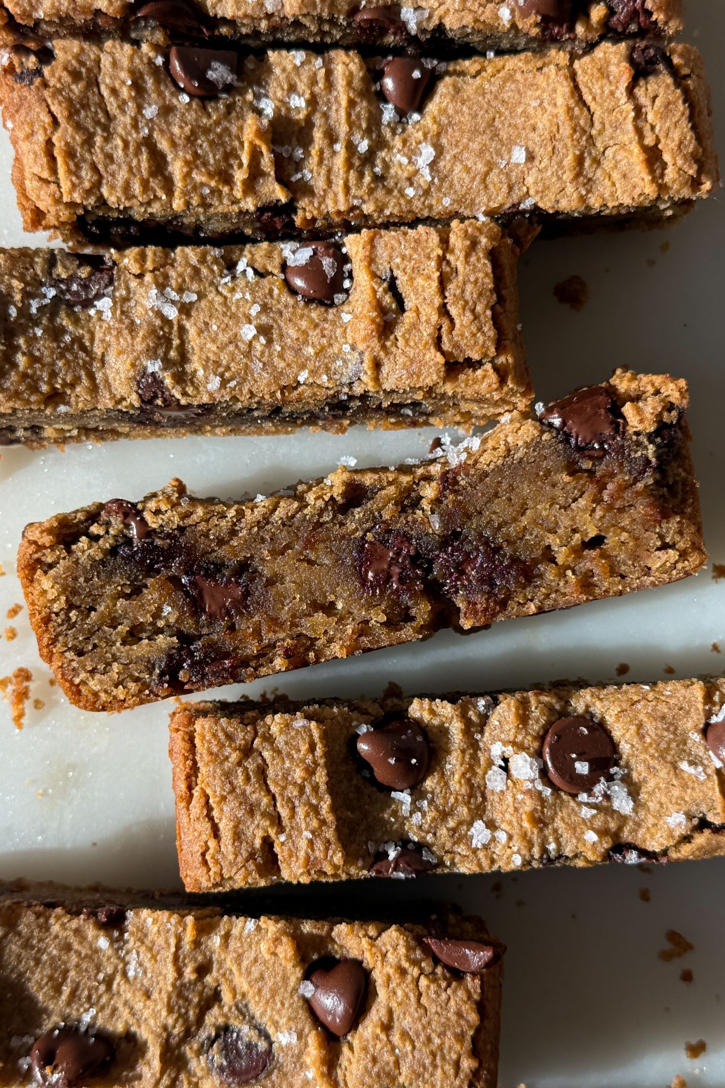 Sliced chickpea blondies on a platter topped with sea salt.