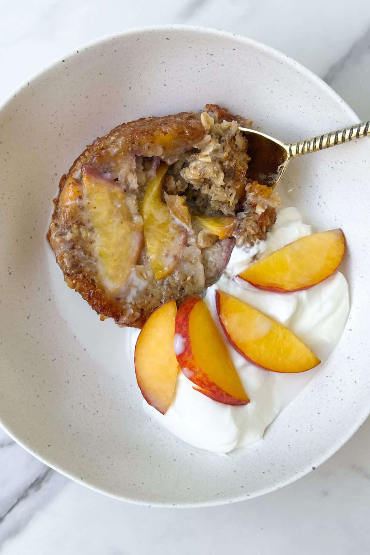 Peach Baked Oatmeal with Cream in a bowl.