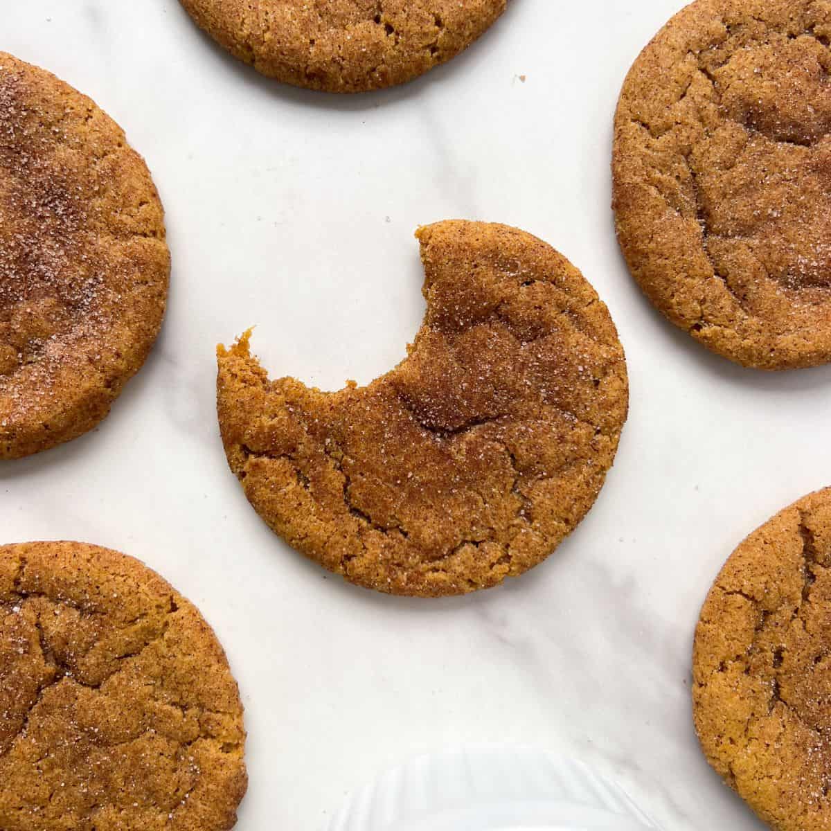 Gluten Free Pumpkin Snickerdoodle Cookie with a bite taken out of it.