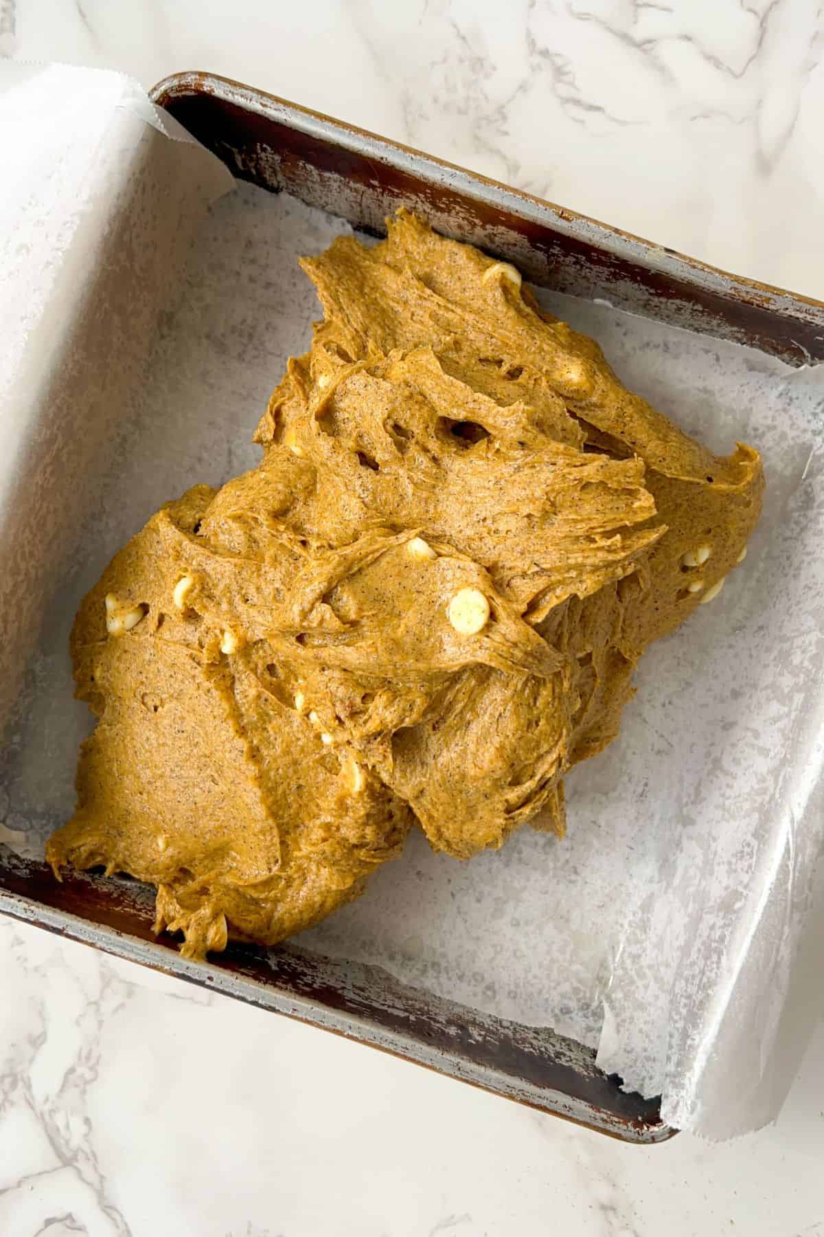 putting the pumpkin bar batter into the lined pan