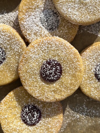 Linzer tart cookies on a baking sheet lined with parchment paper.