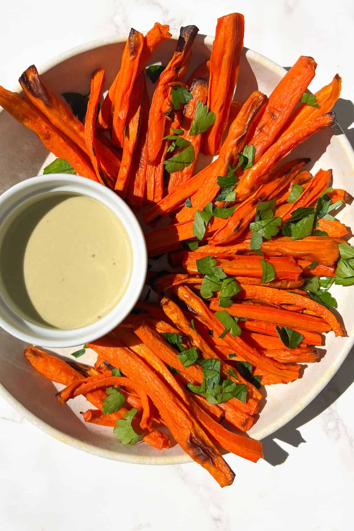 Crispy Carrot Fries in a bowl with a dipping sauce.