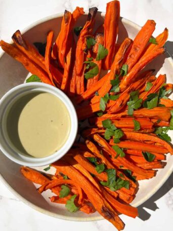 Crispy Carrot Fries in a bowl with dipping sauce.