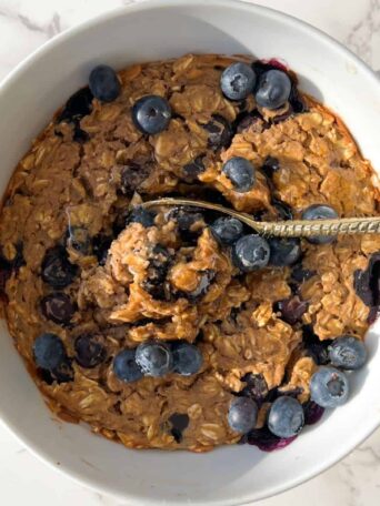 blueberry baked oats without banana topped with fresh blueberries and honey