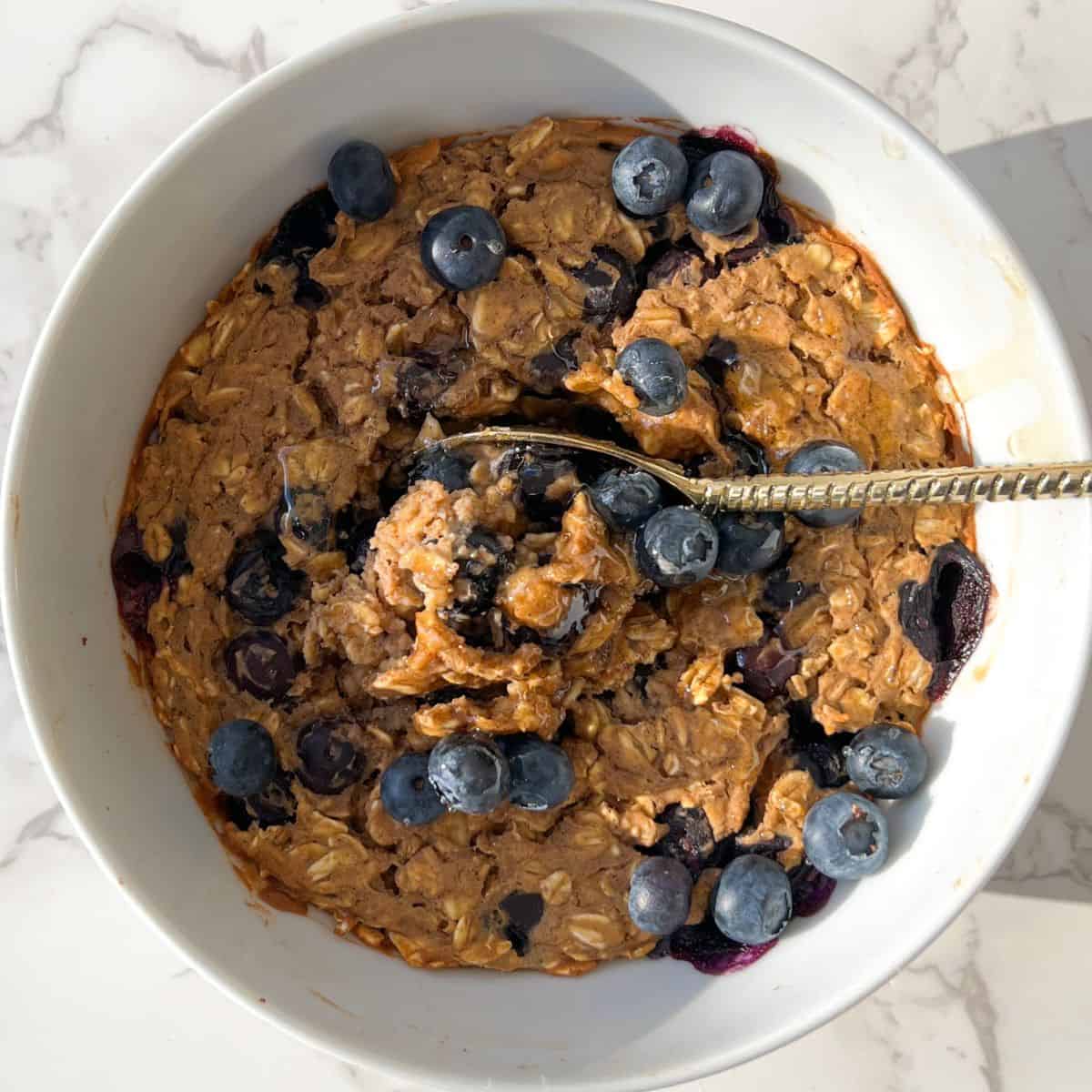 blueberry baked oats without banana topped with fresh blueberries and honey