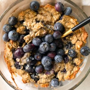 blueberry muffin baked oats in a glass bowl