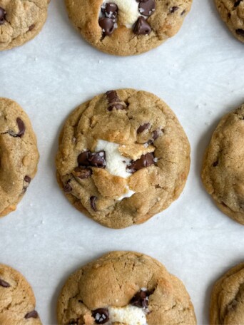 S'mores chocolate chip marshmallow cookies on a baking sheet lined with parchment paper.
