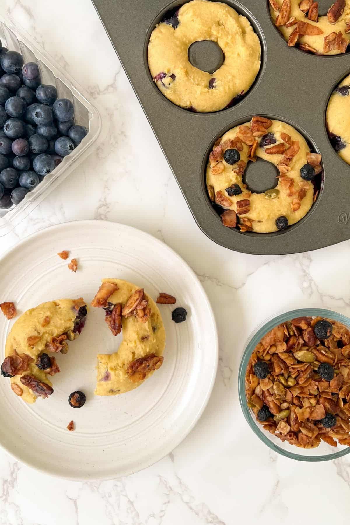 blueberry cake donut topped with granola and a donut on a plate