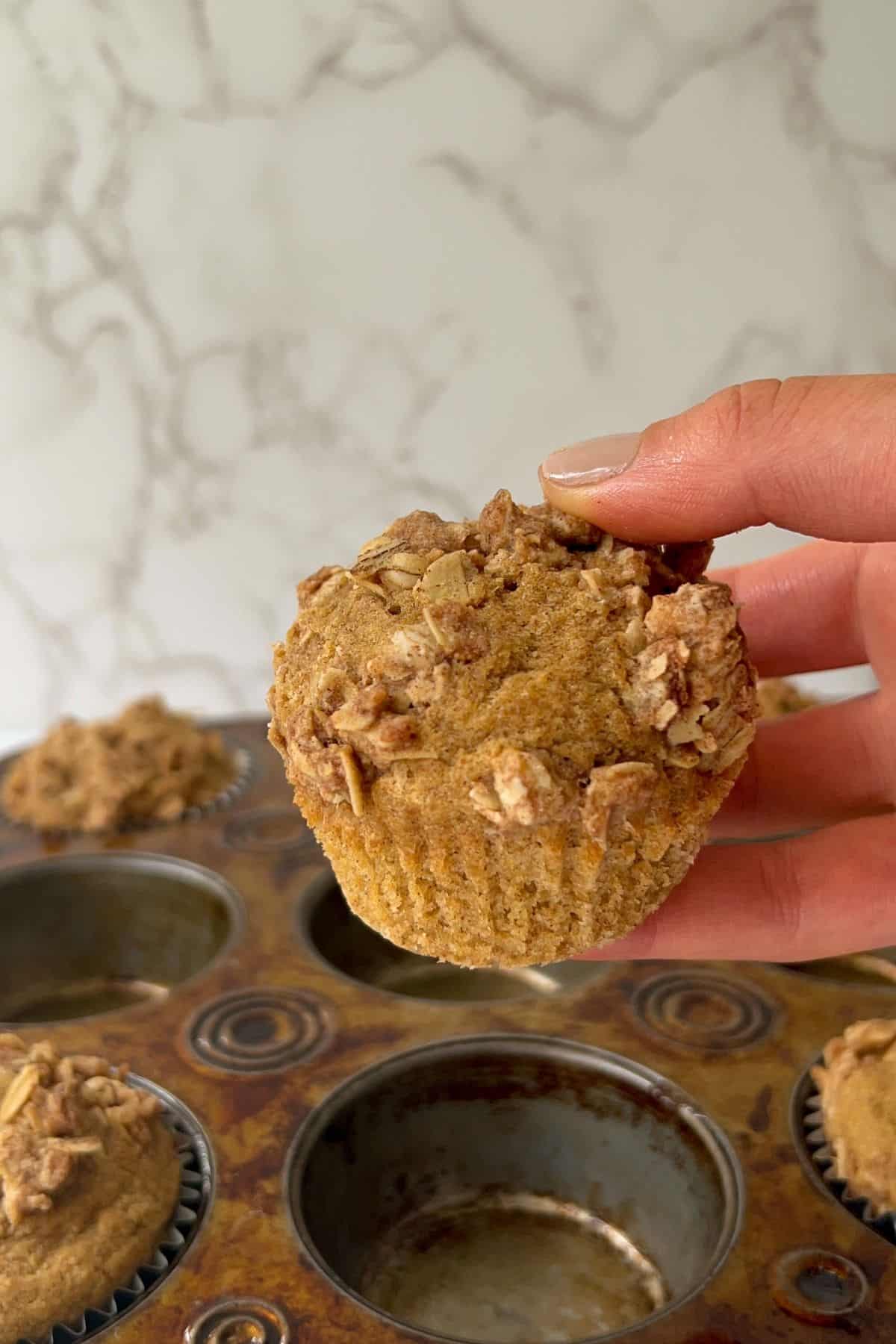 holding a baked gluten free coffee cake muffin