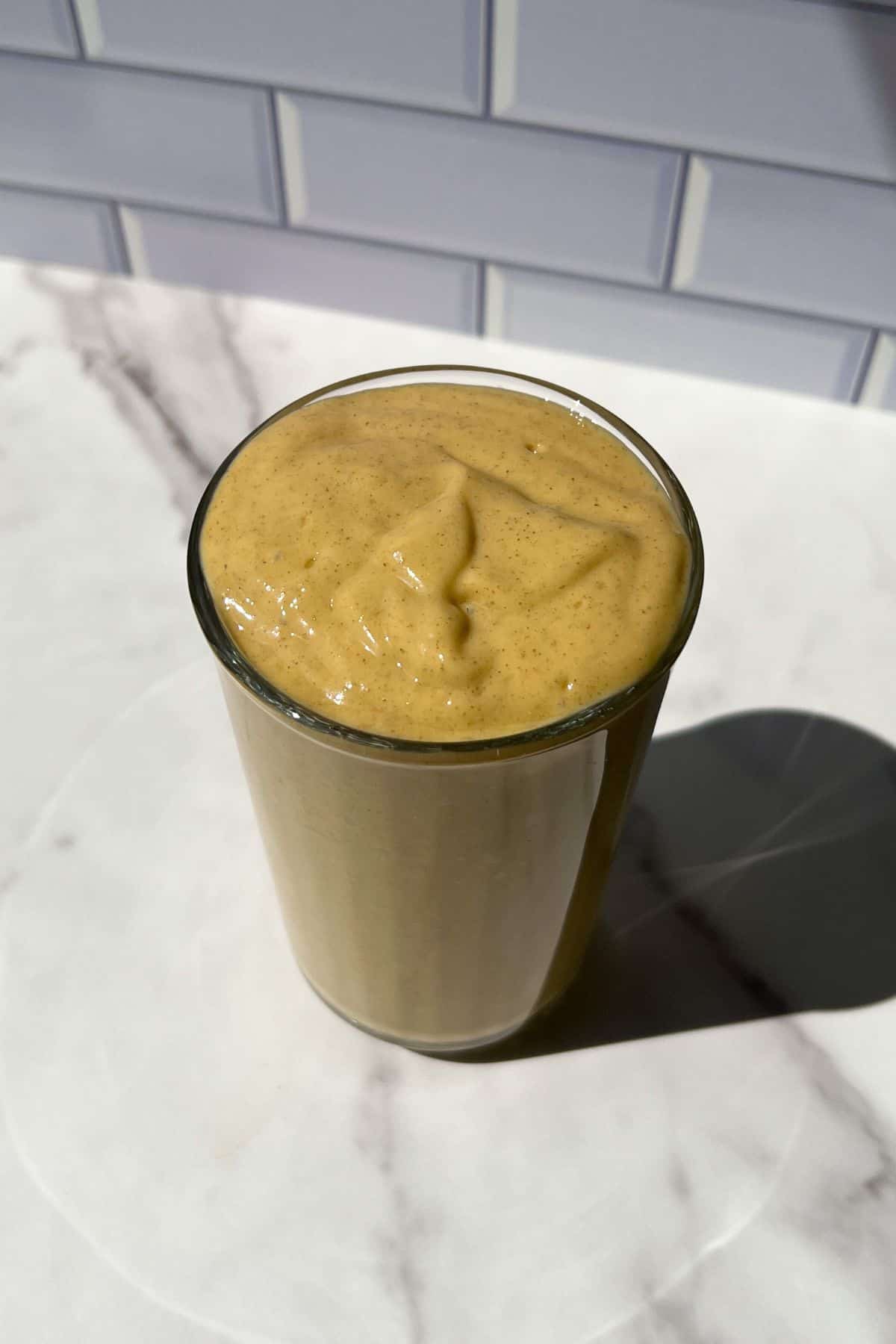 Mango Protein Smoothie poured in a glass.