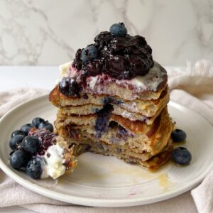 Stack of Healthy Low Calorie Pancakes without Milk topped with blueberries and greek yogurt.