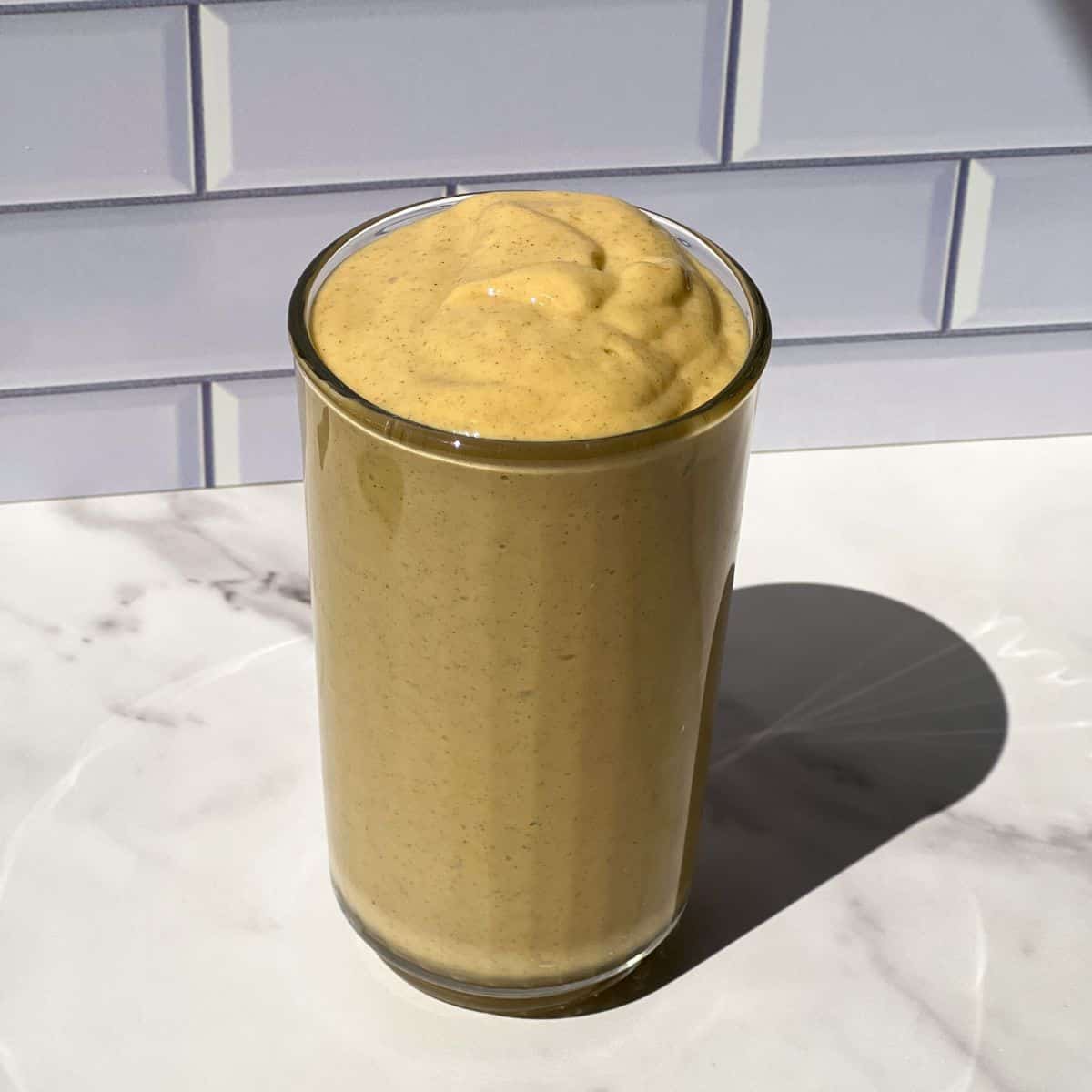 Mango Protein Smoothie poured in a glass.
