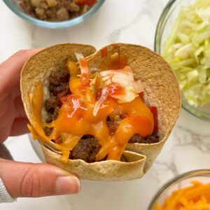 ground beef in a tortilla taco cup with toppings