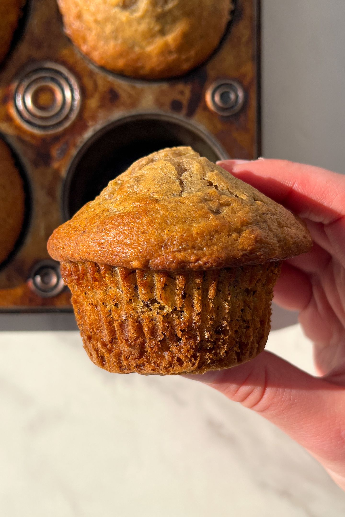 Holding a banana muffin in my hand.