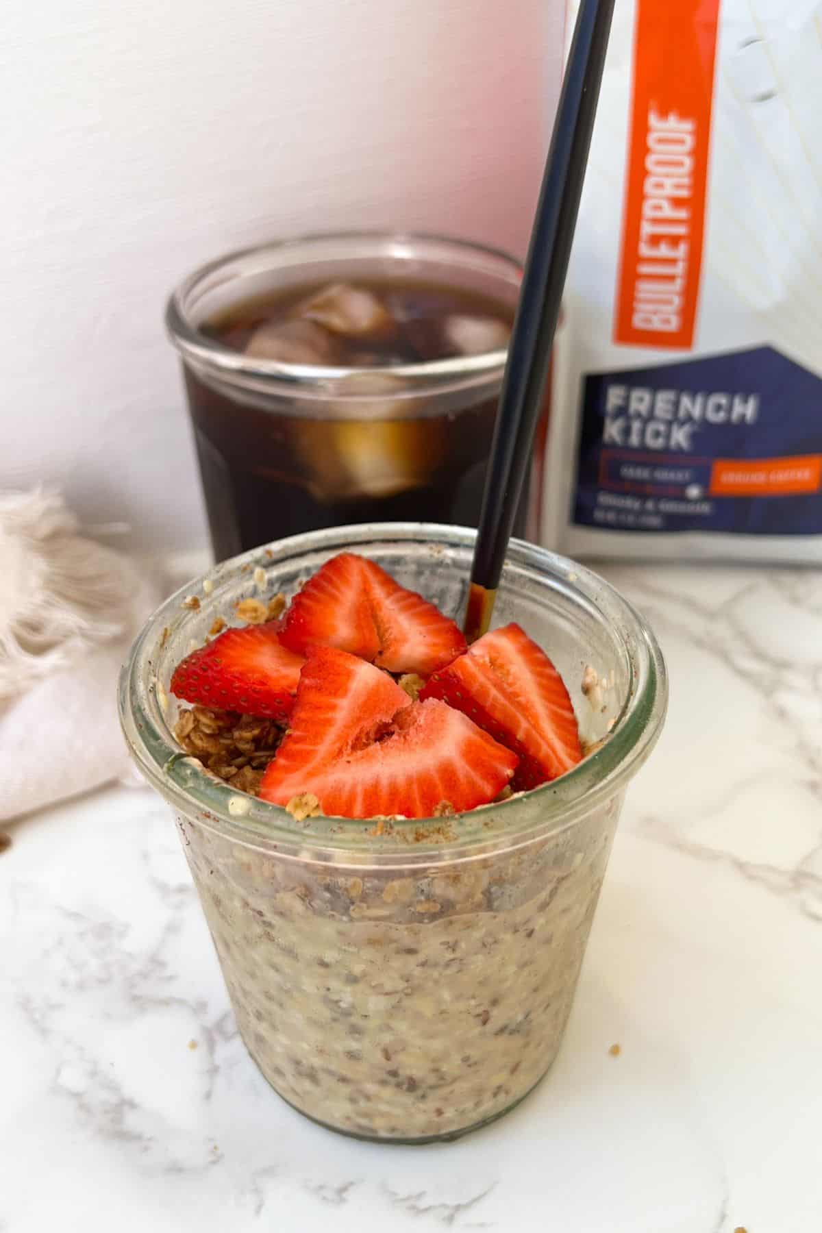 cinnamon overnight oats in a weck jar topped with granola and fresh fruit