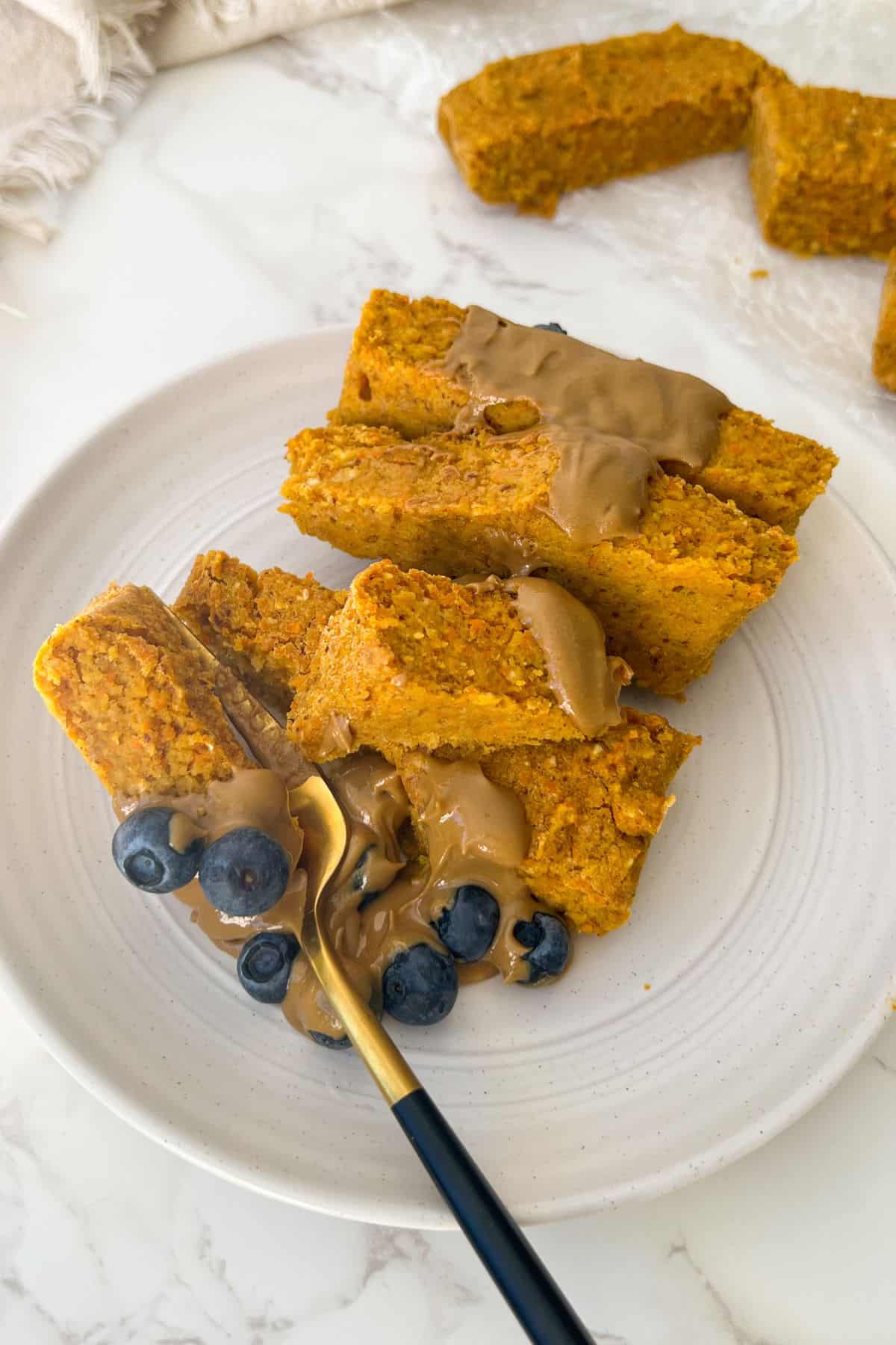 carrot cake oatmeal bars topped with sunflower butter and fresh blueberries