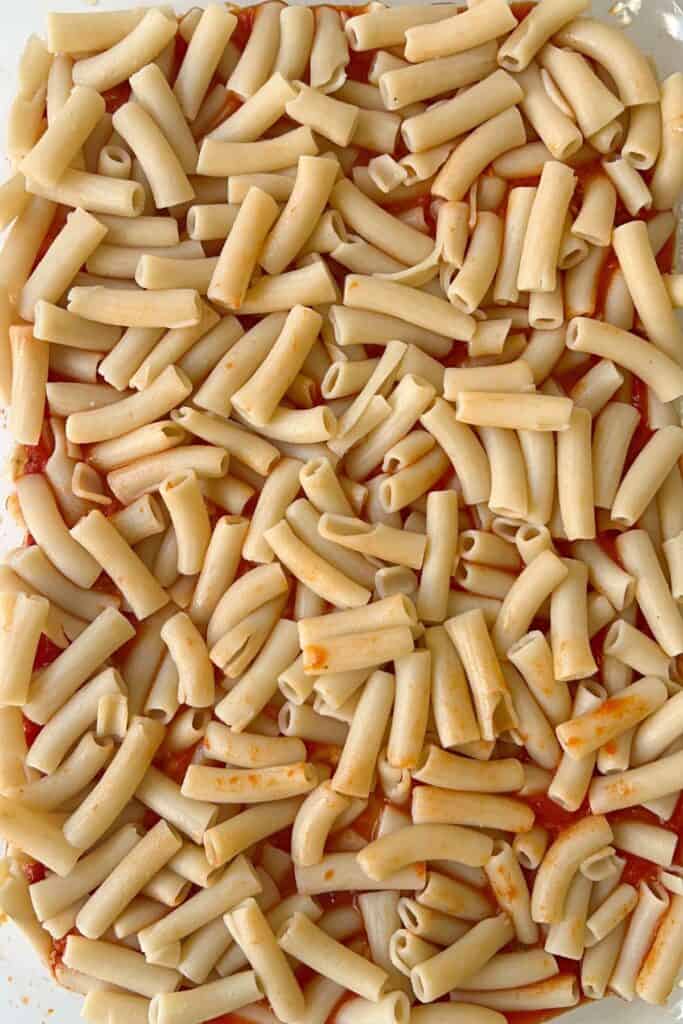 first layer of pasta sauce topped with pasta