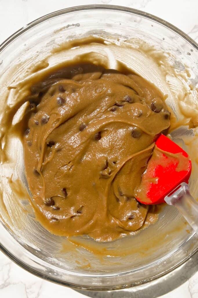 gluten free blondies batter in a bowl with chocolate chips mixed in