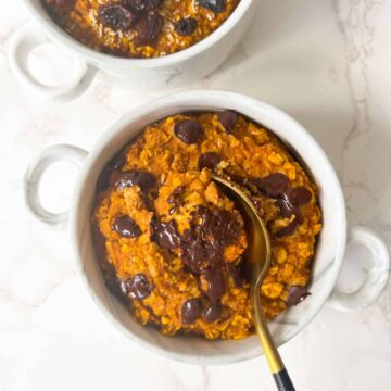 pumpkin baked oats without eggs in a ramekin and topped with chocolate chips