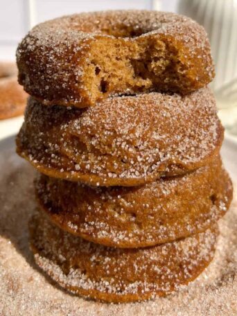 Stack of Gluten Free Apple Cider Donuts coated in cinnamon sugar.