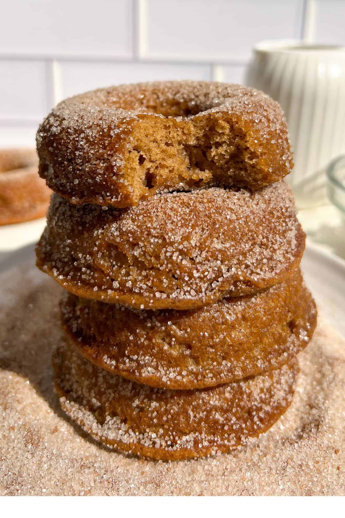 Stack of gluten free apple cider donuts covered in cinnamon sugar.