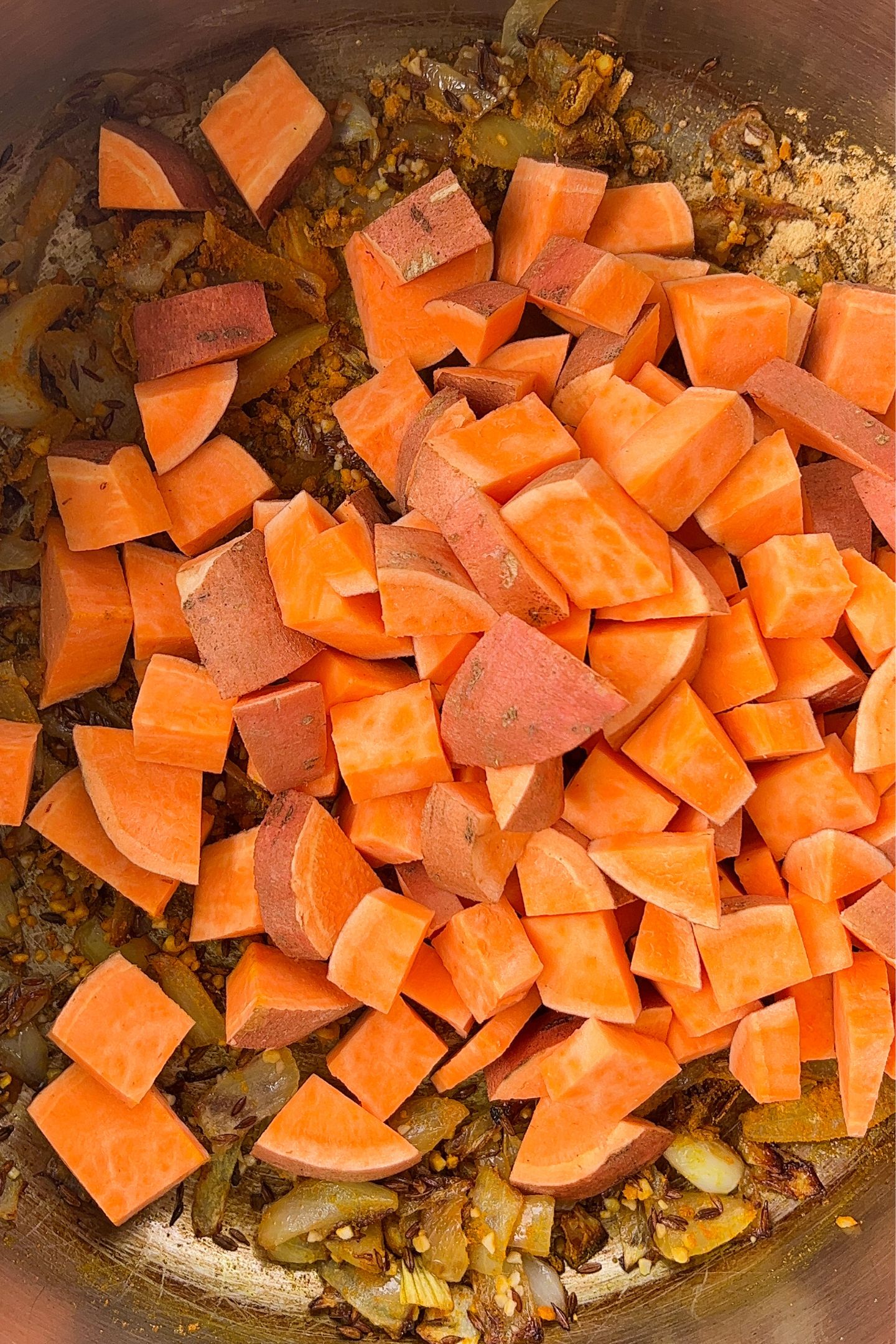 Adding the sweet potato to the pot