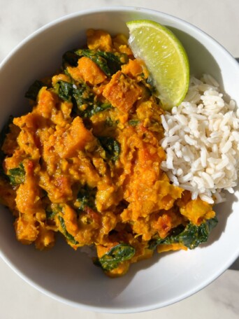 Bowl of sweet potato curry served with rice.