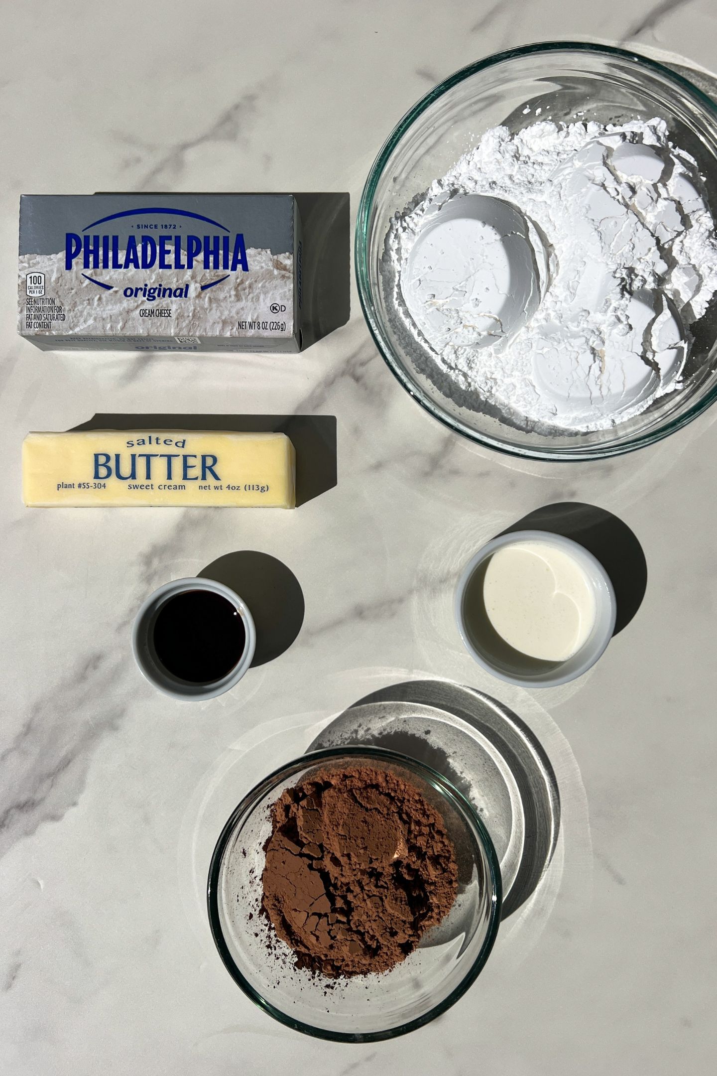 Ingredients measured out in bowls to make chocolate frosting.