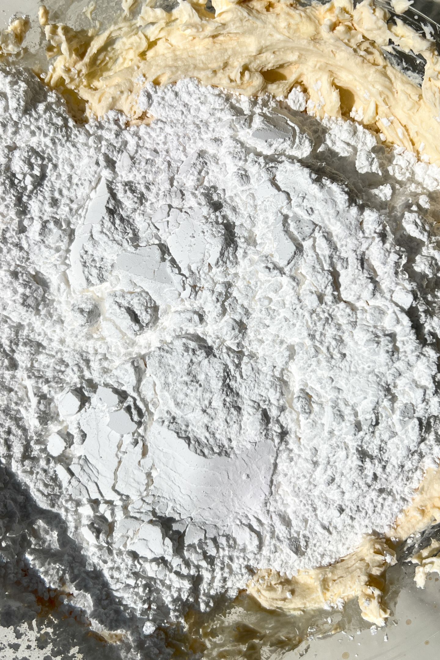 Wet ingredients in a bowl with powdered sugar on top.