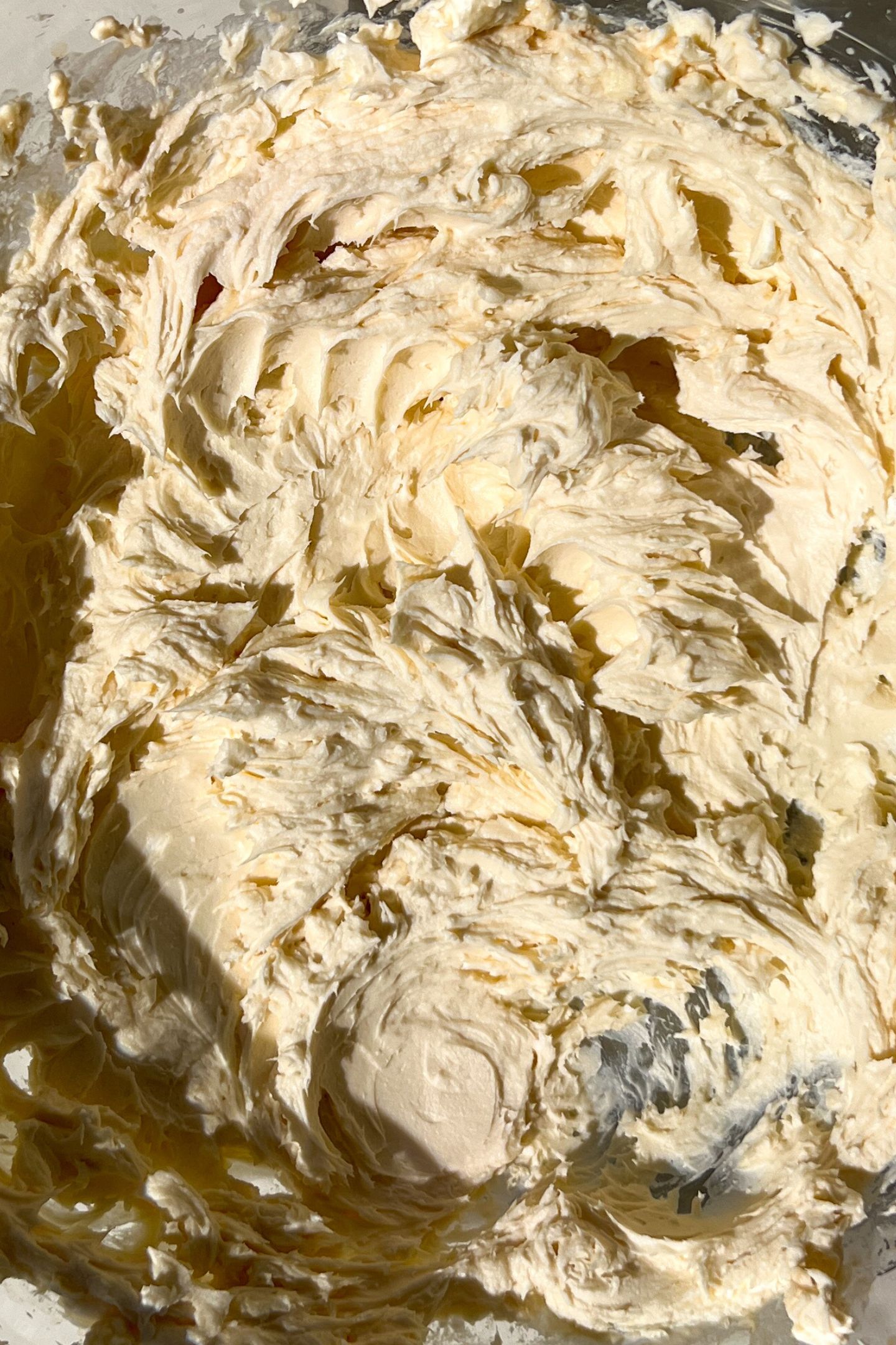 Butter and cream cheese whipped together in a bowl with vanilla and heavy cream.