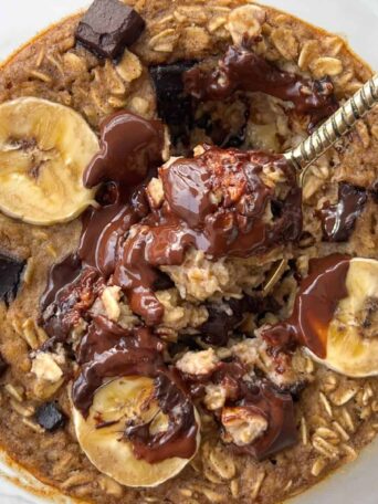 a spoon in a bowl of chocolate chip baked oats without egg