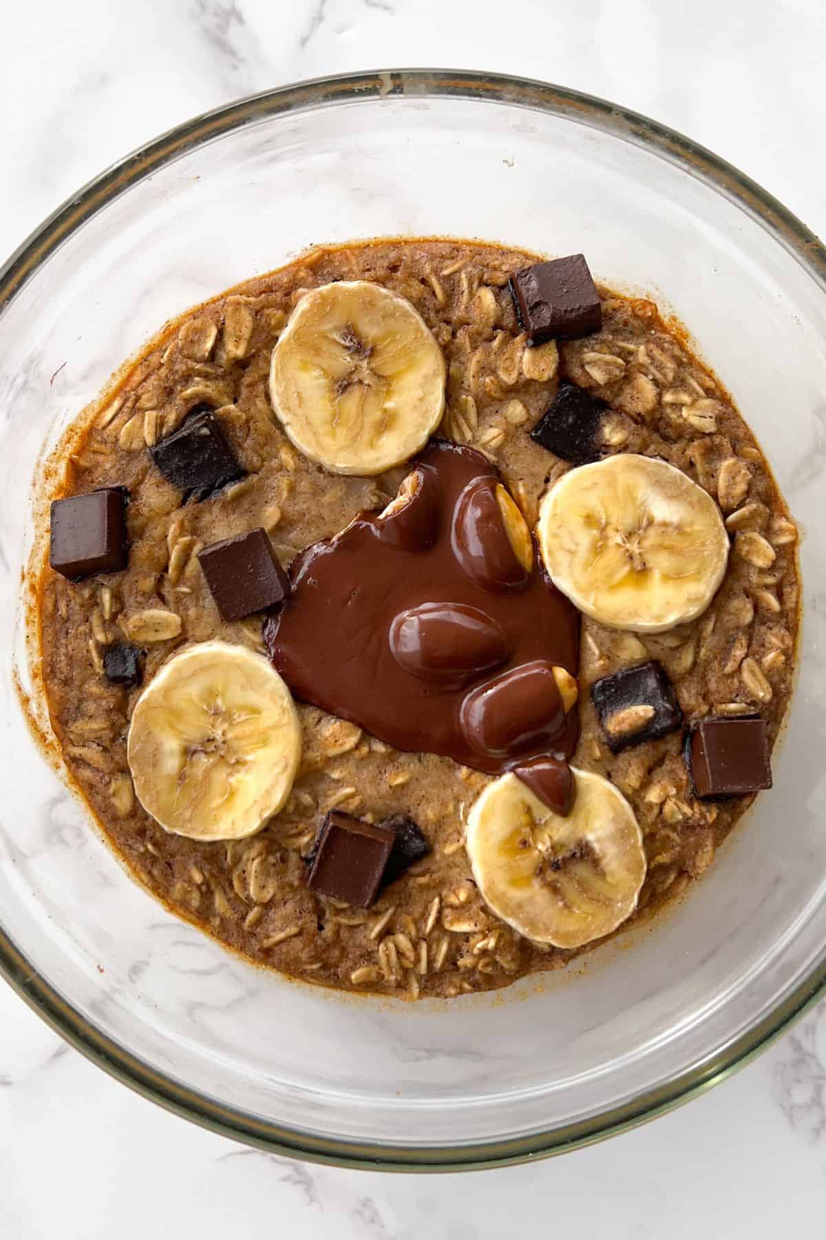 chocolate chip baked oats without egg topped with sliced banana and chocolate