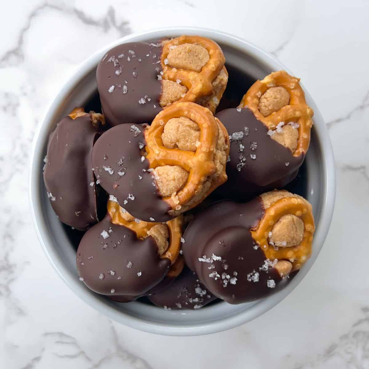 Dark chocolate covered pretzels stuffed with peanut butter in a serving bowl