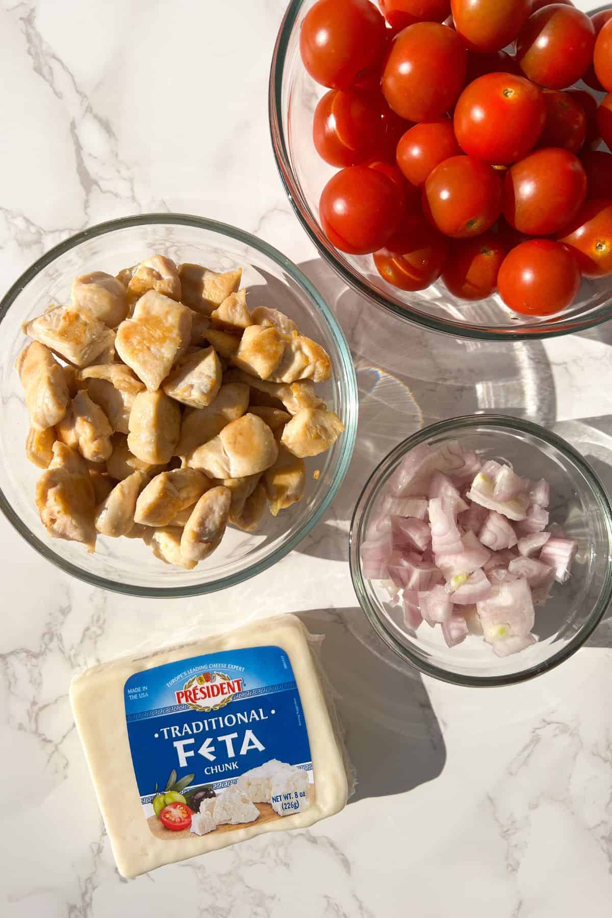 baked chicken feta pasta ingredients prepped in bowls