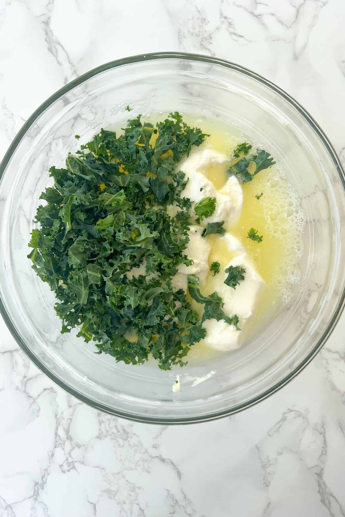 Egg white liquid in a bowl with ricotta cheese and kale.