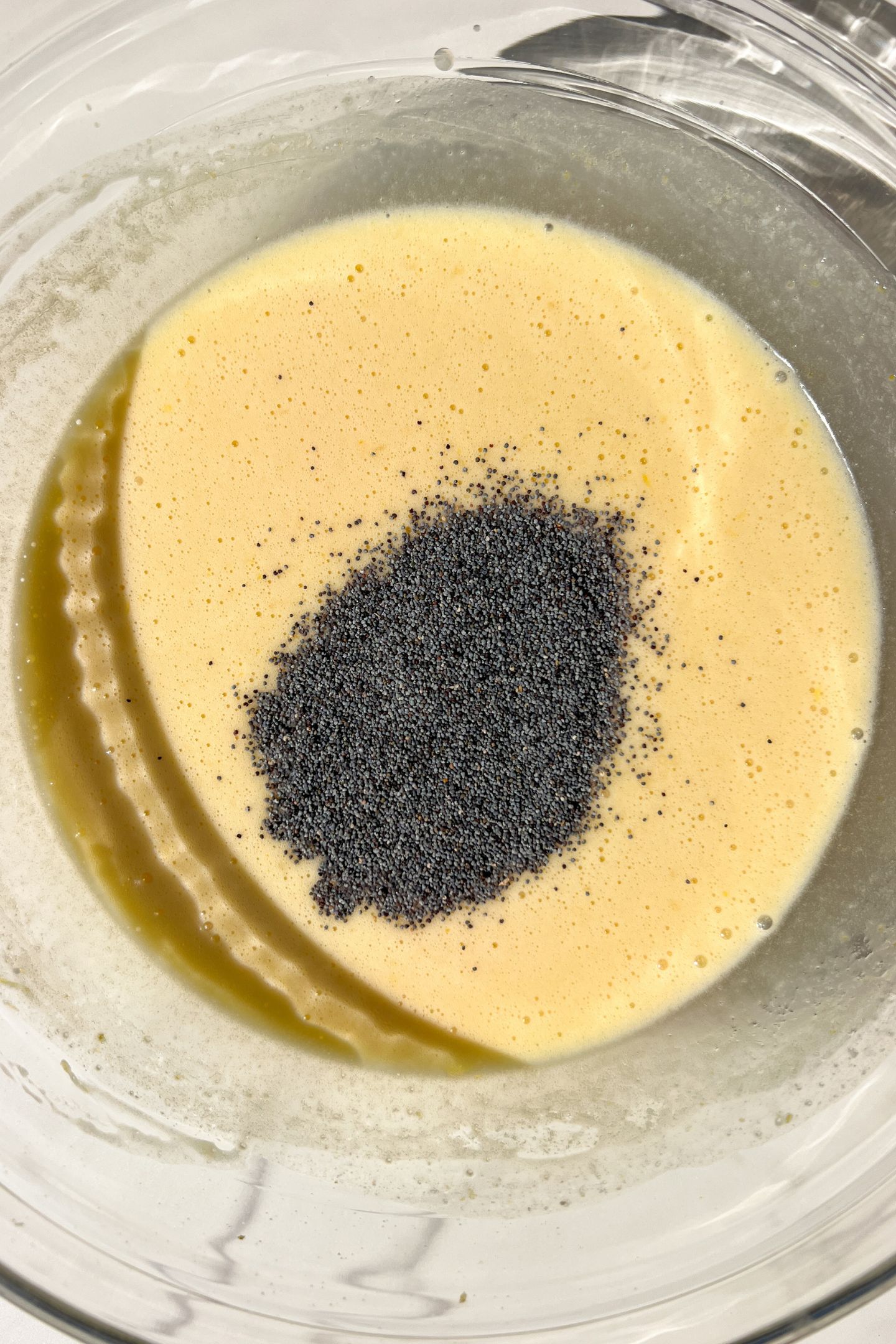 Mixing wet ingredients and poppy seeds in the bowl.