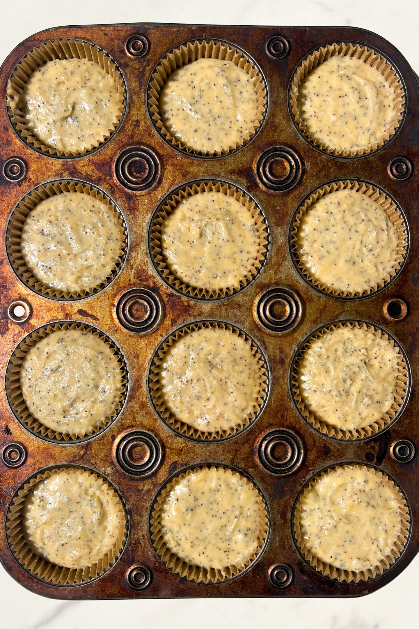 Lemon poppy batter in the muffin liners.