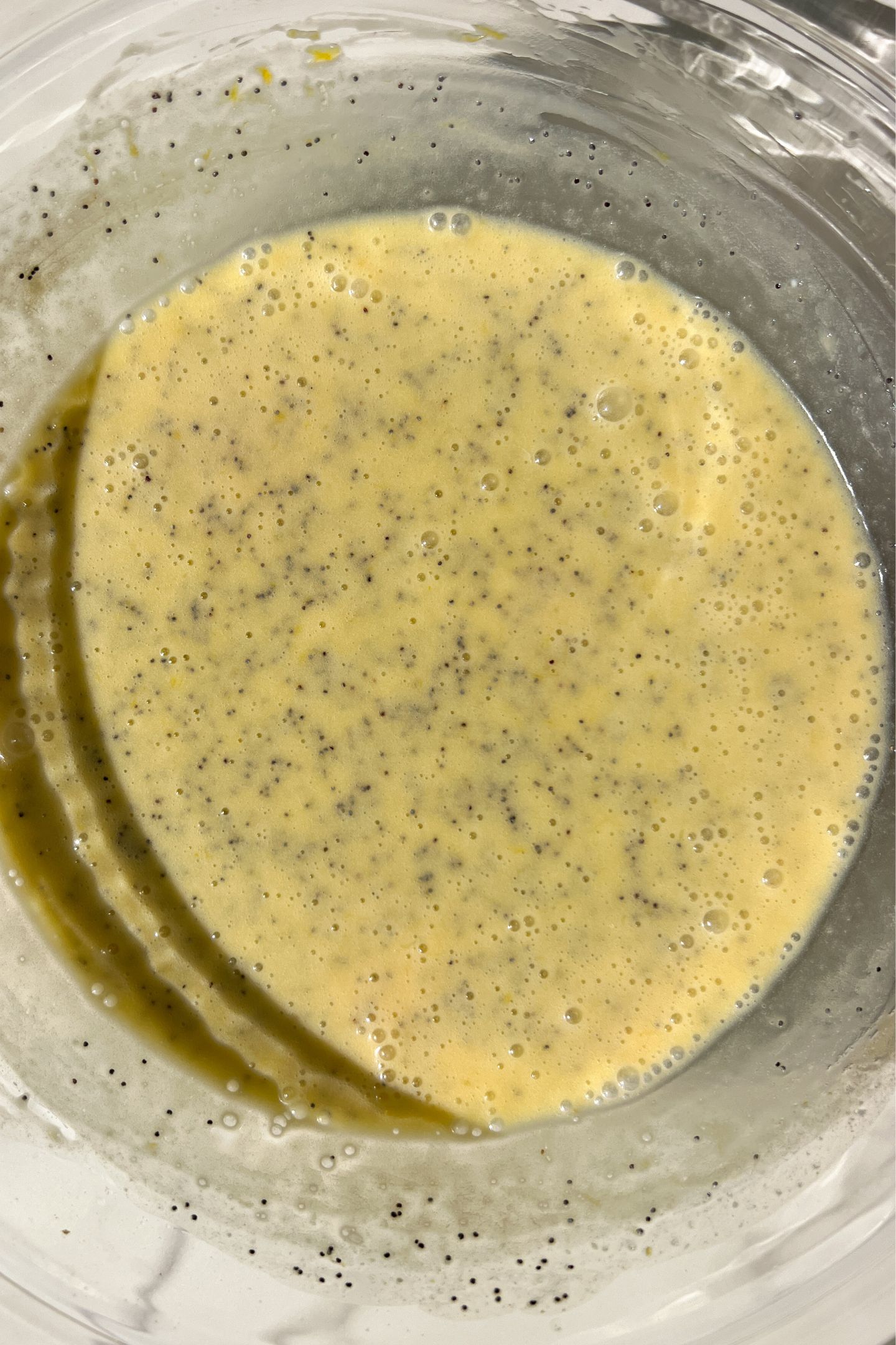 Mixing wet ingredients and poppy seeds in the bowl.