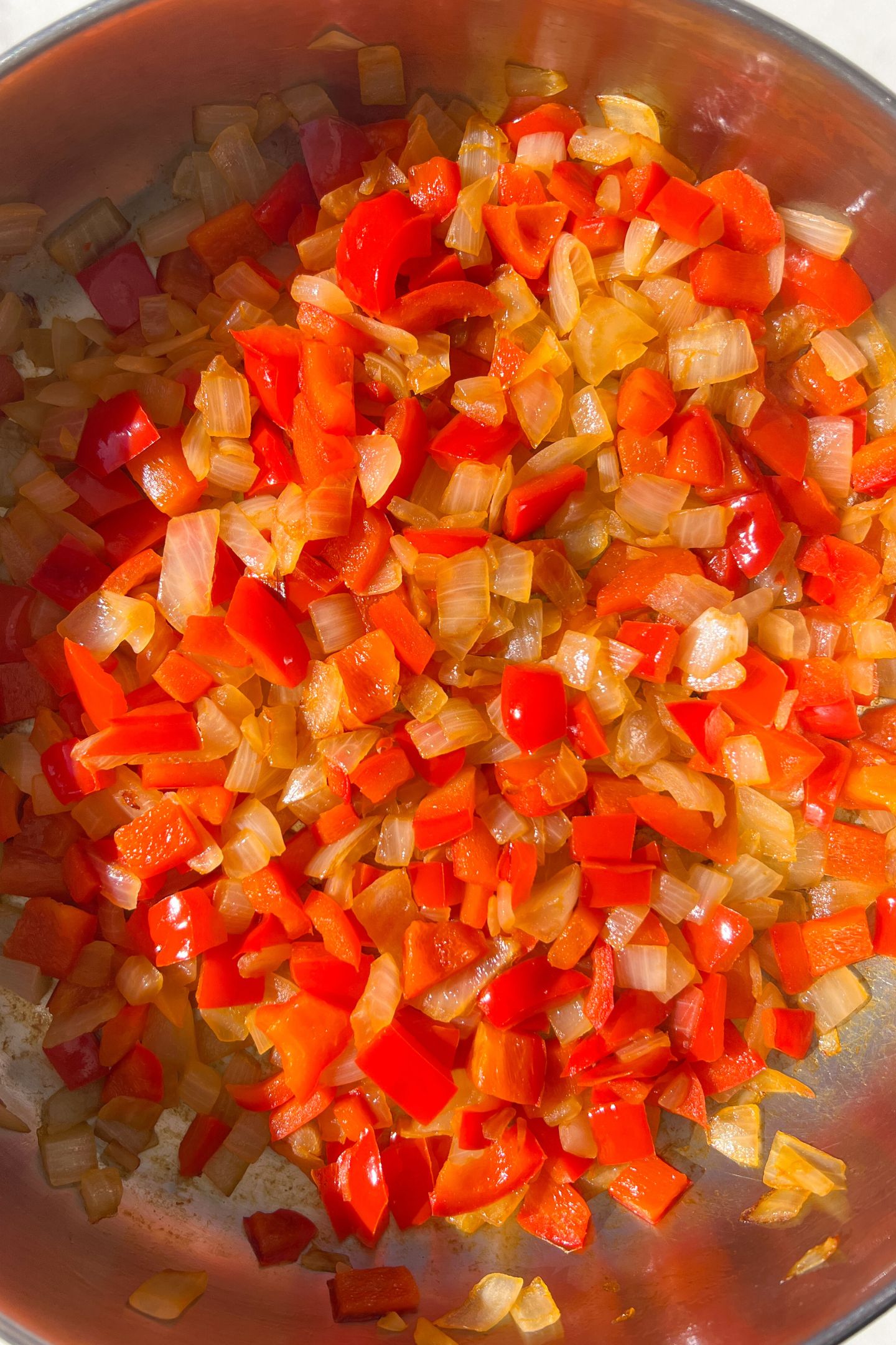 Sautéed peppers and onions in a heated pan.