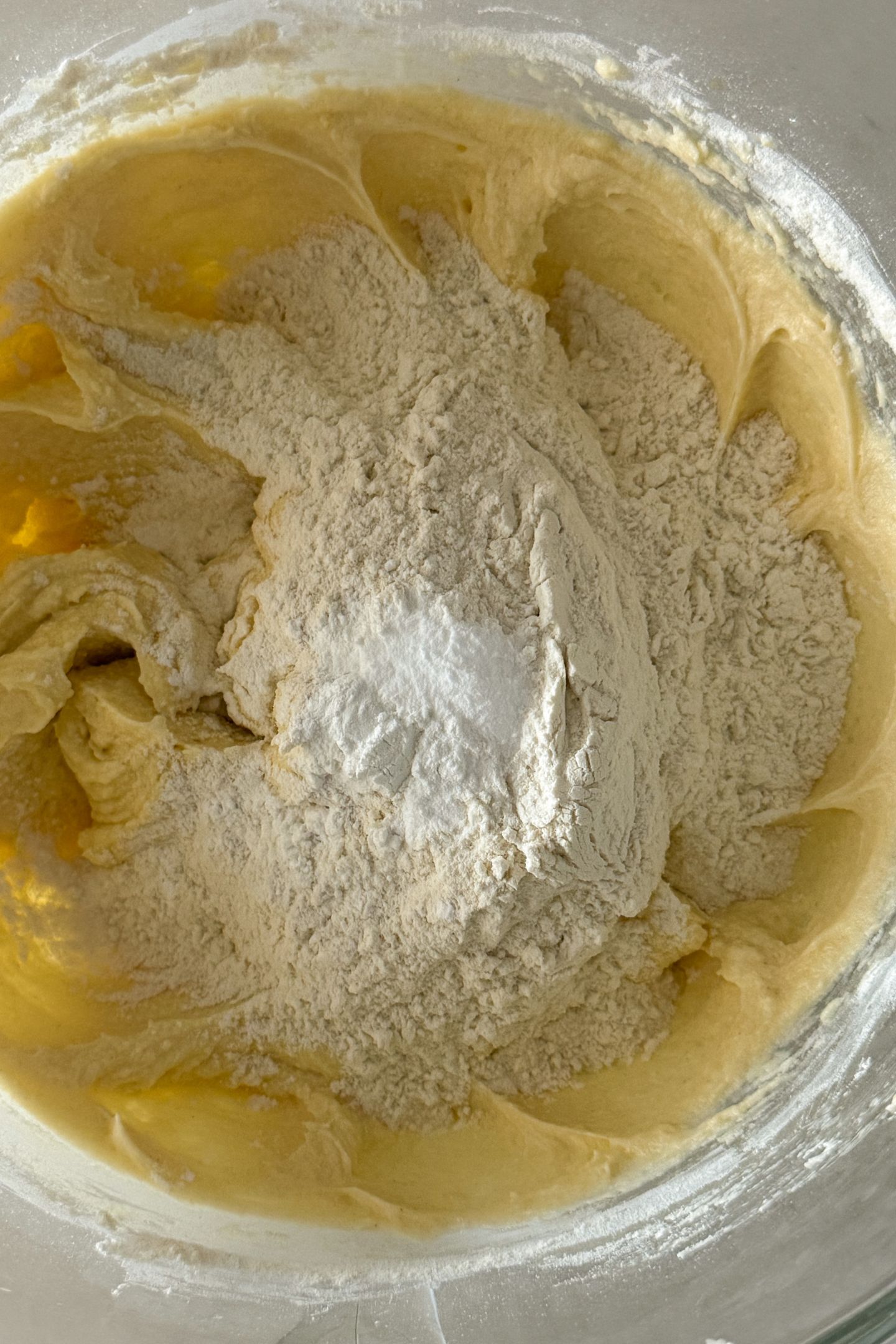 Adding the rest of the flour to the batter as well as the baking powder and the baking soda.