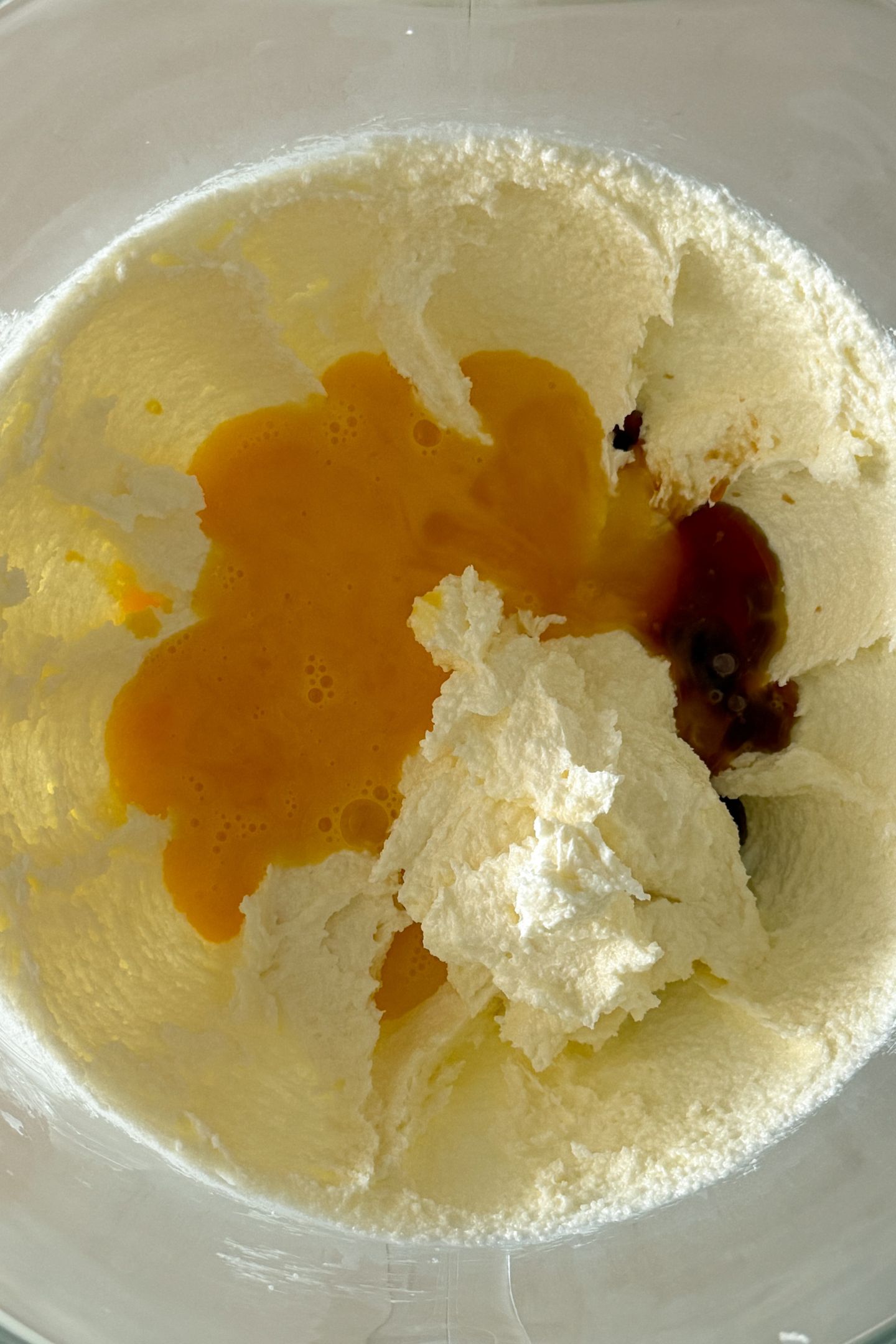 Adding the eggs and vanilla extract to the butter and sugar.