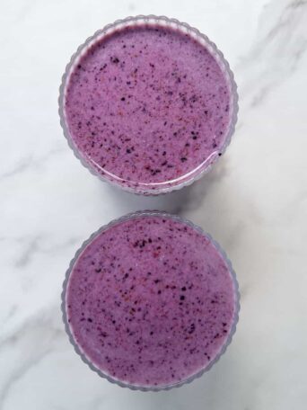 Strawberry Blueberry Banana Smoothie poured into two glasses.
