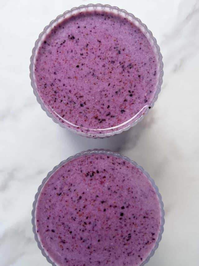Strawberry Blueberry Banana Smoothie poured into two glasses.