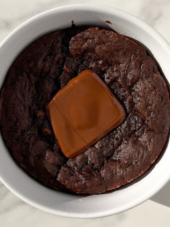 Chocolate Protein Mug Cake topped with a piece of chocolate.