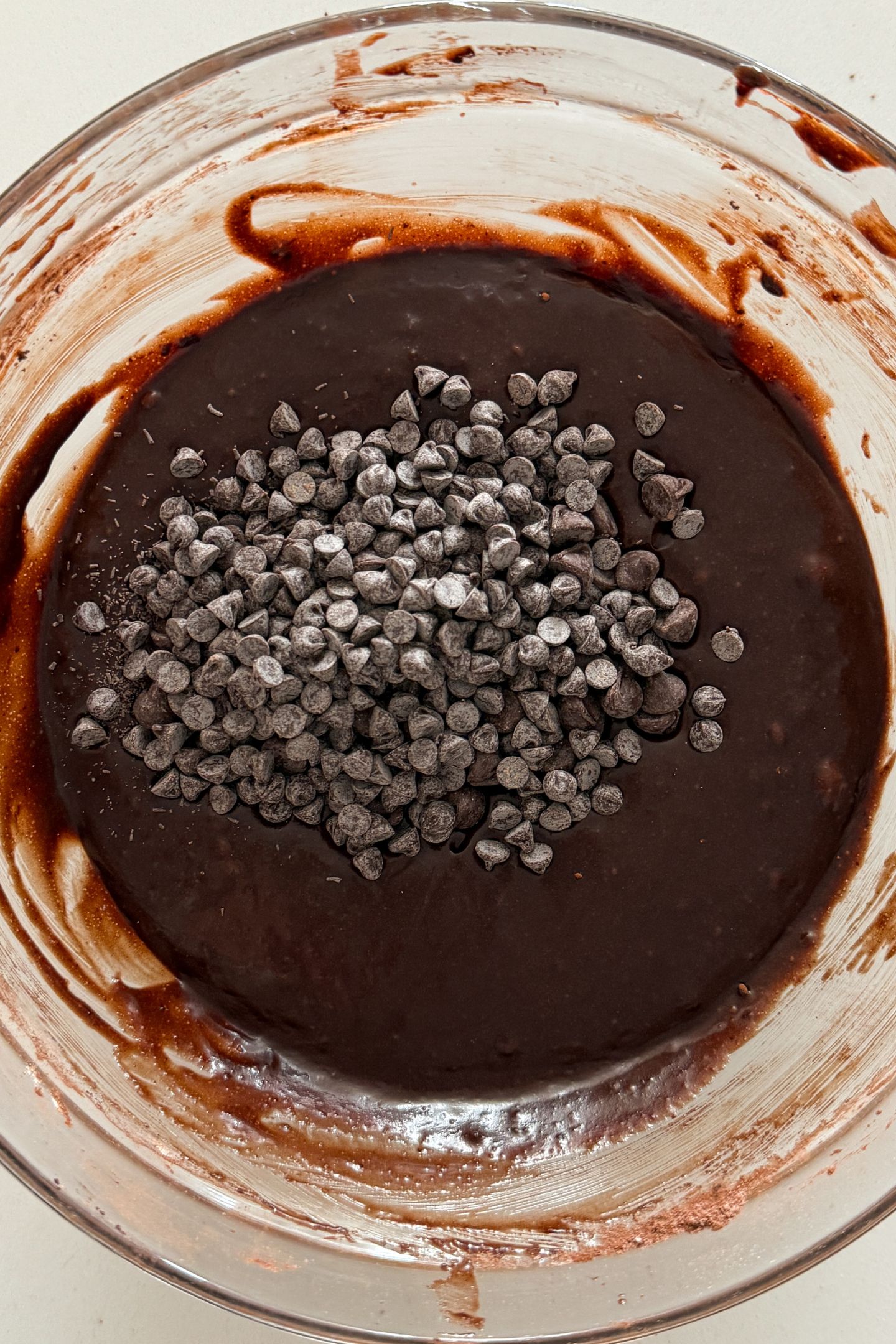 Brownie batter in the large mixing bowl topped with chocolate chips.
