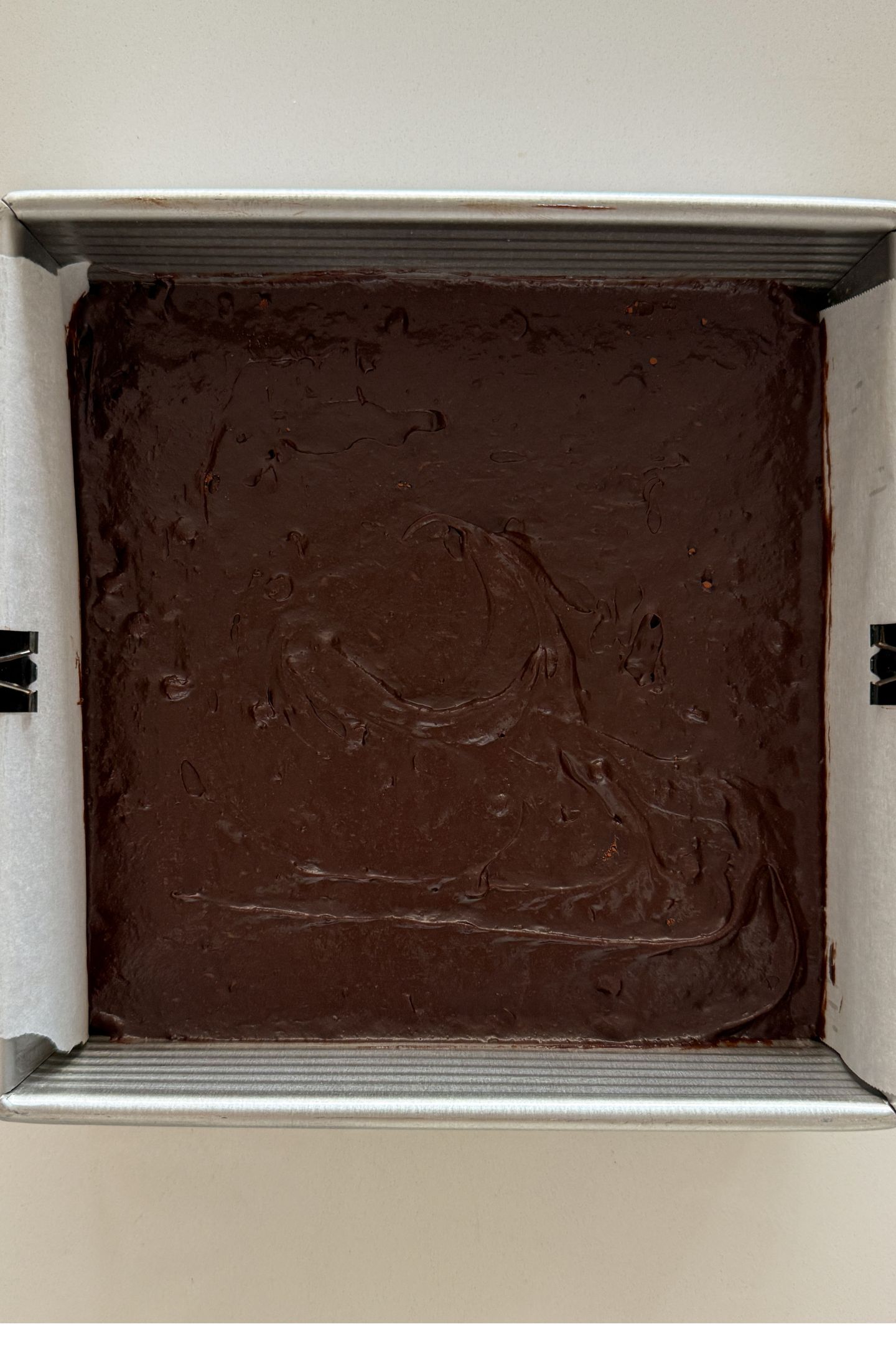 Espresso brownie batter spread out in a square baking pan.