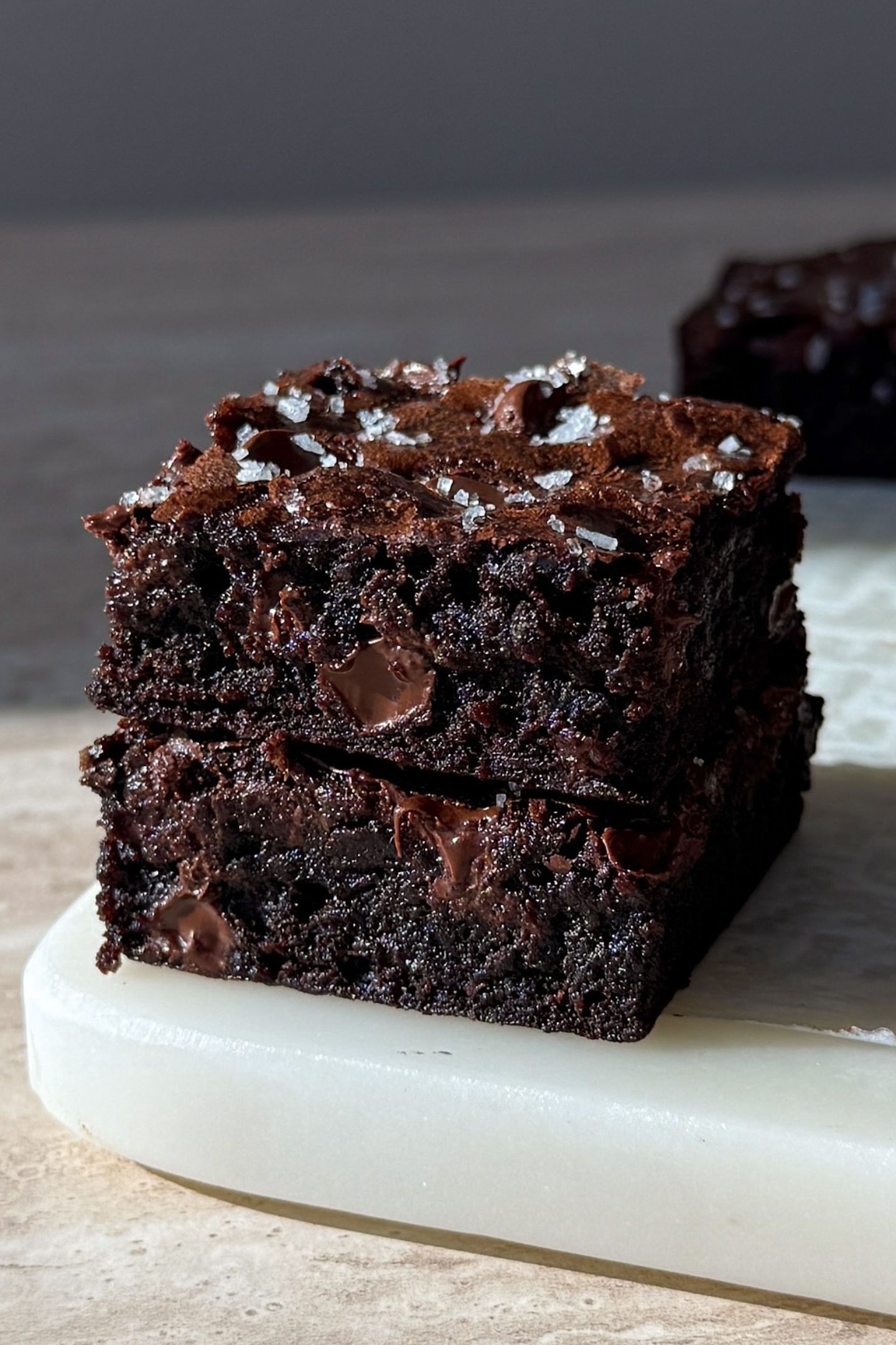 Two brownies stacked on top of each other topped with sea salt.