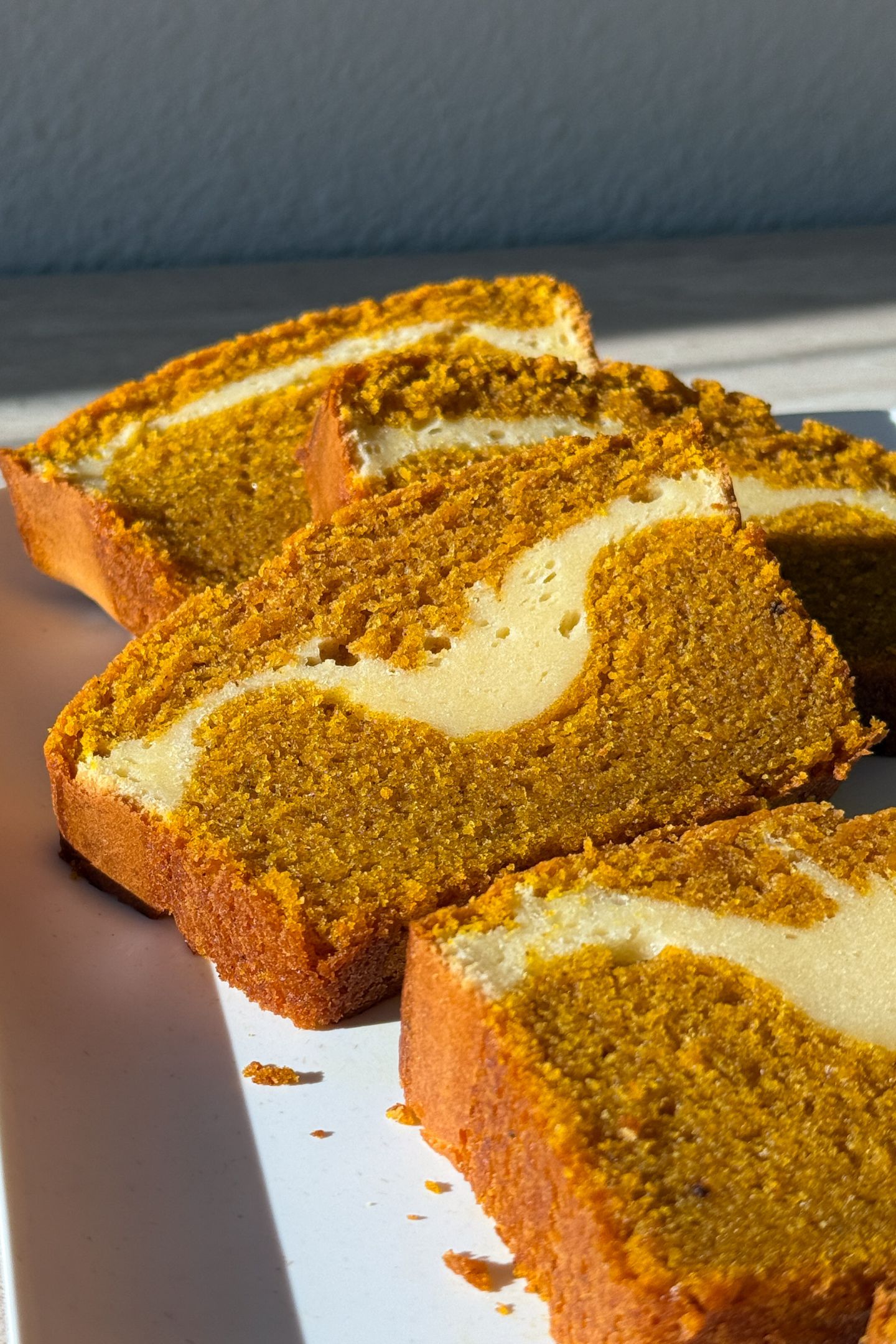 Slices of Pumpkin Cheesecake Bread on a serving platter.