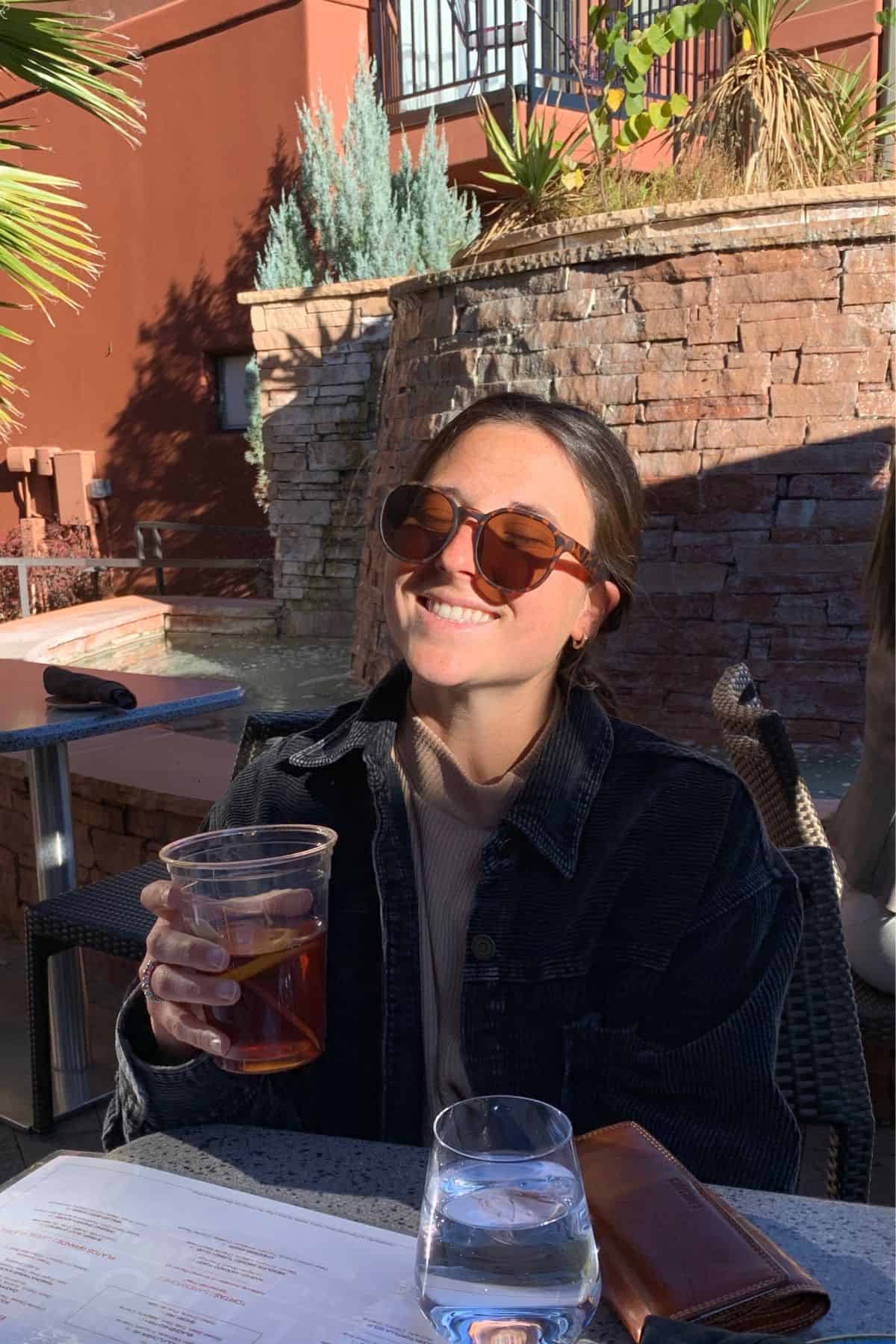 Photo of Jess holding an iced tea in her hand.